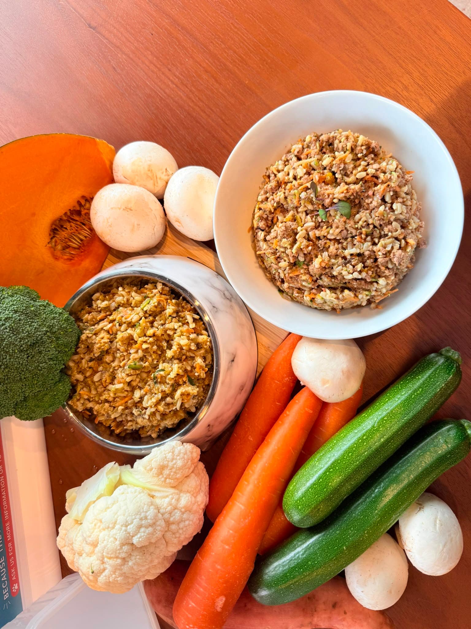 Second overhead flatlay of fresh vegetables around Paw-a-licious bowls